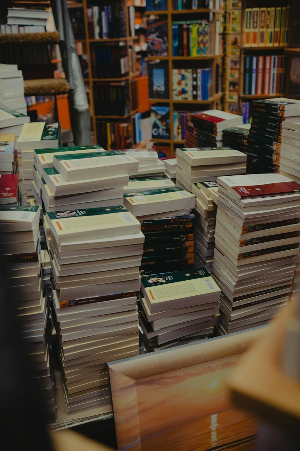 Pile di libri sui tavoli all'interno di una libreria.