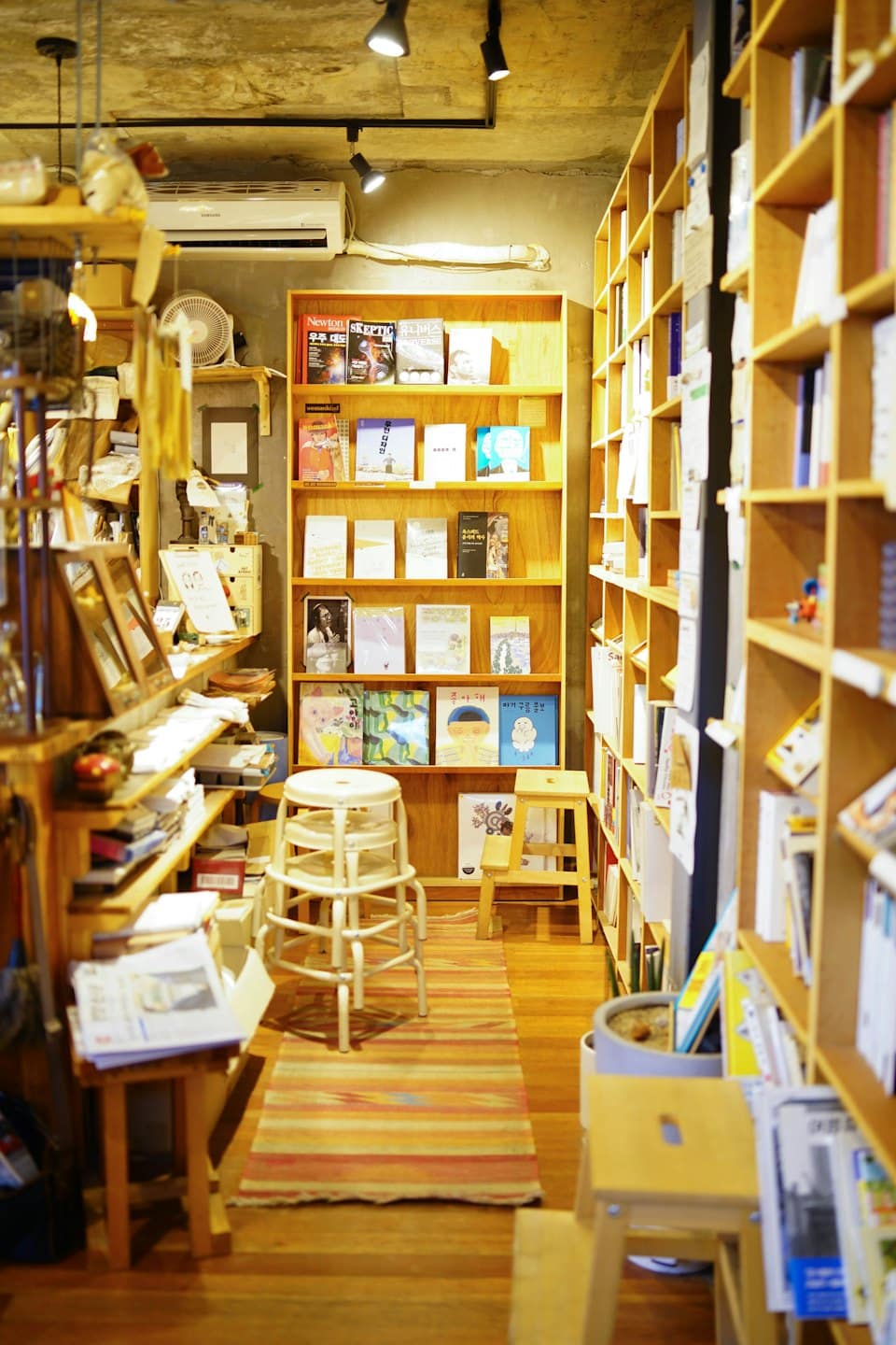 Scaffali di legno pieni di libri fiancheggiano un corridoio di una libreria.